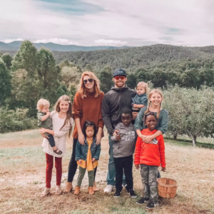 Rosie with her 6 siblings and mom and dad in beautiful photo in the countryside